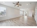 Bright living room featuring light wood flooring, large windows, and a modern ceiling fan at 3831 E 141St Ave, Thornton, CO 80602