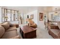 Bright living room with staircase, classic furniture, and view to the kitchen area at 1010 Kennedy Dr, Westminster, CO 80234