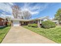 Charming brick ranch home with a well-manicured front yard and a long driveway to an attached garage at 1669 S Kearney St, Denver, CO 80224