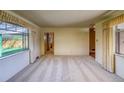 Spacious living room with neutral carpeting, large windows, and a view into other parts of the home at 1669 S Kearney St, Denver, CO 80224