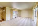 Bright living room featuring neutral carpet, large windows with curtains, and a view of the front yard at 1669 S Kearney St, Denver, CO 80224
