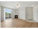 Open concept living room features a fireplace, access to a balcony, and neutral paint at 7440 S Blackhawk St # 2-203, Englewood, CO 80112