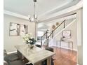 Neutral dining room featuring hardwood floors, decorative light fixture, and a nearby staircase at 12627 Fisher Dr, Englewood, CO 80112