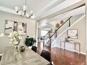 Neutral dining room with hardwood floors, elegant light fixture, view of staircase and nearby living area at 12627 Fisher Dr, Englewood, CO 80112