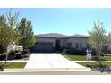 Beautiful single-story home with a large concrete driveway, well-manicured lawn, and professional landscaping at 26741 E Peakview Pl, Aurora, CO 80016