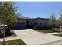 Charming single-story home with a meticulously maintained lawn, professional landscaping, and a paved concrete driveway at 26741 E Peakview Pl, Aurora, CO 80016