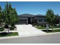 Charming home with a well-manicured lawn, spacious driveway, and inviting curb appeal on a sunny day at 26741 E Peakview Pl, Aurora, CO 80016