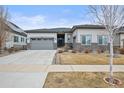 Charming single-story home with neutral exterior, well-maintained lawn, and attached two-car garage at 26741 E Peakview Pl, Aurora, CO 80016