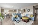 Beautiful living room featuring hardwood floors, stylish seating, and an eat-in kitchen at 26741 E Peakview Pl, Aurora, CO 80016
