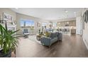 Bright open-concept living room features hardwood floors, large windows, and modern furnishings at 26741 E Peakview Pl, Aurora, CO 80016