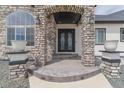 Detailed entrance with custom iron door, stone pillars, and decorative planters at 29585 E 165Th Ave, Brighton, CO 80603