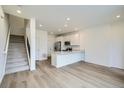 Modern kitchen with stainless steel appliances and a breakfast bar, open to the living area at 700 N Bently St, Watkins, CO 80137