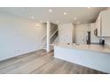 Modern kitchen with stainless steel appliances, white cabinets, and breakfast bar at 700 N Bently St, Watkins, CO 80137