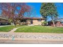 Inviting single-story home with brick accents, mature trees, and a well-manicured lawn at 4625 S Huron St, Englewood, CO 80110