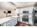 Bright kitchen featuring white cabinets, stainless appliances, and elegant chandelier at 16522 Bluebonnet Dr, Parker, CO 80134