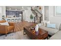 Open concept living space with hardwood floors, a modern staircase, and stylish furnishings at 12242 W 56Th Pl, Arvada, CO 80002