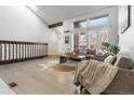Open-concept living room with hardwood floors, large windows, and plenty of natural light at 2822 S Uinta St, Denver, CO 80231