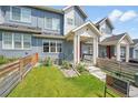 Two-story townhome with a small front yard, covered porch, and visible 'For Sale' sign at 6211 W 28Th Ct, Wheat Ridge, CO 80214