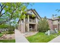 Inviting two-story condo featuring brick accents, dual balconies, and landscaped grounds at 23451 E 5Th Dr # 203, Aurora, CO 80018