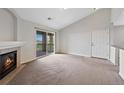 Bright living room with fireplace, neutral carpet, and sliding glass door to a private balcony at 23451 E 5Th Dr # 203, Aurora, CO 80018