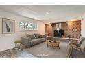 Cozy basement with brick fireplace, gray sofa and wood flooring, offering a relaxing retreat at 13086 E Alaska Ave, Aurora, CO 80012
