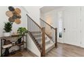 Inviting entryway featuring hardwood floors, stairs with black iron spindles, and stylish decor at 13220 E 110Th Pl, Commerce City, CO 80022