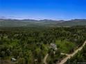 Scenic aerial view of the luxury home nestled within a lush mountain landscape at 28532 Hummingbird Hill Rd, Conifer, CO 80433