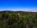 Expansive aerial view of the property surrounded by mountain scenery and lush foliage at 28532 Hummingbird Hill Rd, Conifer, CO 80433