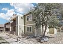 Exterior view of a condo with natural landscaping and a beautiful mature tree at 3450 S Eagle St # 101, Aurora, CO 80014