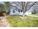 Charming light blue house with landscaped front yard and mature trees on a sunny day at 9765 Merimbula St, Highlands Ranch, CO 80130