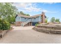 Exterior of home showing brick accents, front-facing garage, and a staircase leading to an upper-level entrance at 7930 Alkire St, Arvada, CO 80005