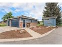 Detached garage and small shed with matching paint and trim, as well as nicely landscaped yard space at 7930 Alkire St, Arvada, CO 80005