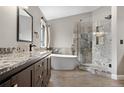 Elegant bathroom showcasing a freestanding tub, glass-enclosed shower, and stylish granite-topped vanity at 8922 S Tuscany Ln, Highlands Ranch, CO 80130