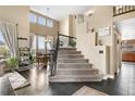 Inviting entryway boasting high ceilings, hardwood floors, carpeted stairs, and an open dining area at 8922 S Tuscany Ln, Highlands Ranch, CO 80130