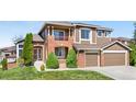 Charming two-story home featuring a brick facade, a cozy balcony, and a well-maintained lawn at 8922 S Tuscany Ln, Highlands Ranch, CO 80130