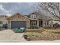 Inviting home showcasing a brick and siding exterior, complemented by a cozy front porch and mature landscaping at 333 Mesa St, Brighton, CO 80601