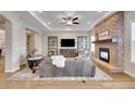 Inviting living room with a stone fireplace, plush seating, built-in shelving and hardwood floors at 27615 E Moraine Dr, Aurora, CO 80016