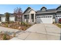 Charming home featuring white brick and gray siding with a two-car garage and walkway landscaping at 23936 E River Front Dr, Aurora, CO 80019