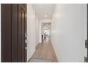 Inviting hallway with light wood floors and neutral white walls leading to other rooms in the house at 23936 E River Front Dr, Aurora, CO 80019