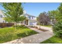 Attractive home featuring a well-maintained lawn, mature trees, and a two-car attached garage at 15649 E 7Th Cir, Aurora, CO 80011