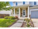 Inviting front porch with stone pillars, manicured bushes, and a flower bed leading to the entrance at 15649 E 7Th Cir, Aurora, CO 80011