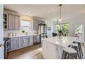 Bright kitchen featuring stainless steel appliances, gray cabinets, and a large center island with seating at 15649 E 7Th Cir, Aurora, CO 80011