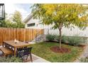 Backyard with a wooden dining table, chairs, a new fence and a well maintained lawn at 3422 S Grant St, Englewood, CO 80113