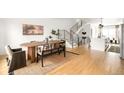 Bright dining room boasts a large wood table, modern decor, and an adjacent staircase with black metal railings at 3422 S Grant St, Englewood, CO 80113