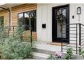 Close up of a modern home exterior with a striking black door and manicured landscaping at 3422 S Grant St, Englewood, CO 80113