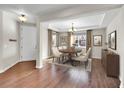 Sunlit dining area with hardwood floors, a round table, and a modern chandelier at 12762 Fisher St, Englewood, CO 80112