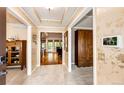 Elegant foyer featuring tiled floors, decorative wallpaper, and a glimpse into the living spaces beyond the entrance at 10601 E Crestline Ave, Englewood, CO 80111