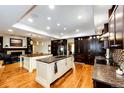 Spacious kitchen boasts dual islands, dark cabinetry, modern appliances, and hardwood floors at 10601 E Crestline Ave, Englewood, CO 80111