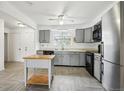 Well-lit kitchen featuring tile flooring, gray cabinets, modern appliances, and an island at 18830 E 16Th Pl, Aurora, CO 80011