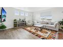 Bright living room with white walls, wood floors, stylish rug, and comfortable seating at 1884 Myron Ct, Erie, CO 80516